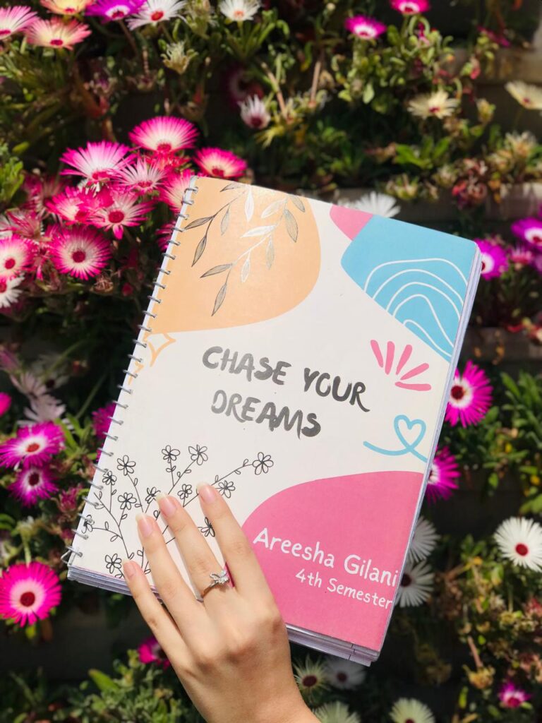 A clean, minimal grey spiral notebook featuring a bold blue motivational quote about the sun in a modern typographic layout.